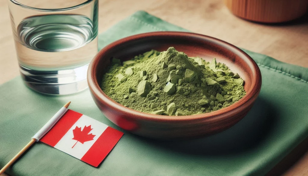 Kratom powder in a wooden bowl with a Canadian flag and glass of water on a green surface.